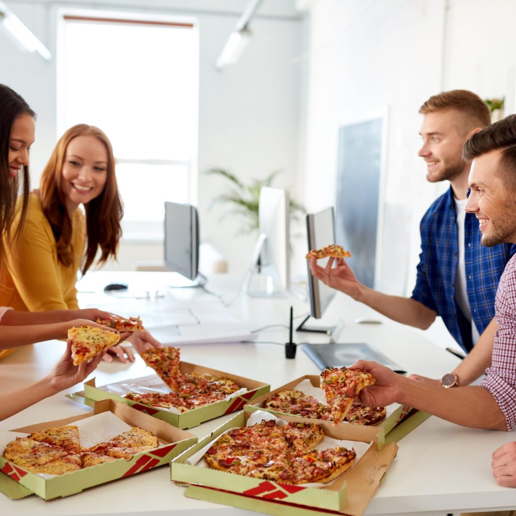 diverse groep mensen die bij een pizza hun werk bespreken. De werkpizza.